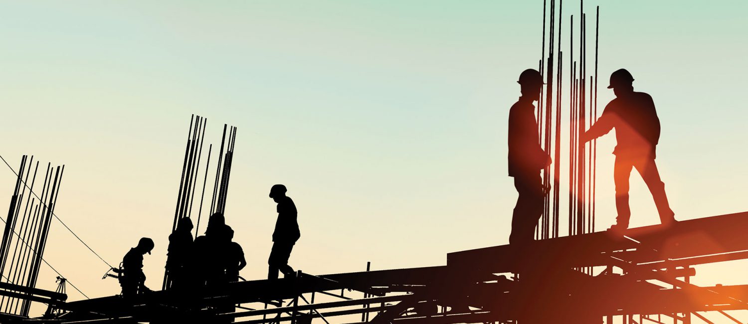 Silhouette of construction workers on scaffolding